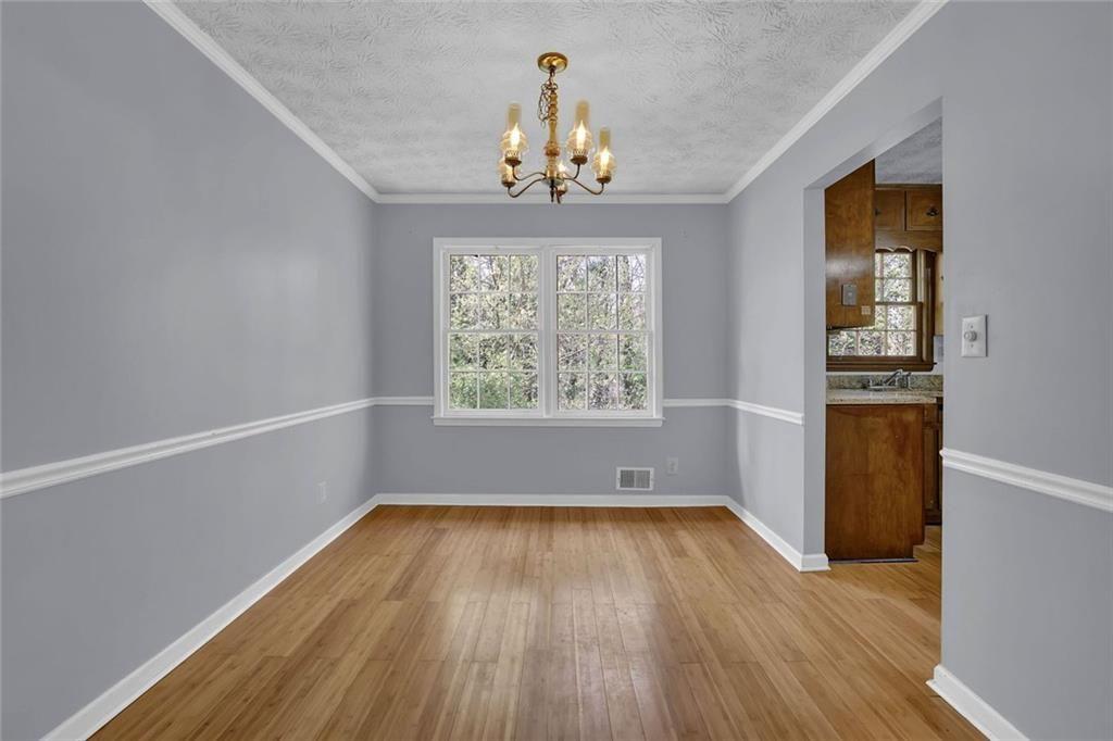 4341 Five Forks Trickum Road Southwest Lilburn, GA 30047 - Photo 17 of 35 wooden floor in an empty room with a window