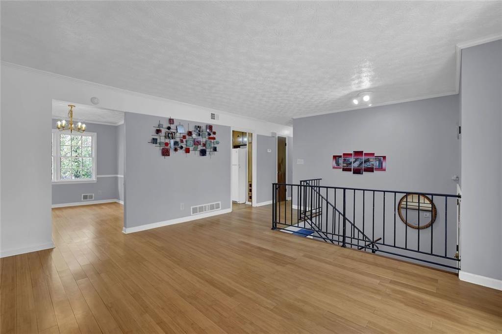 4341 Five Forks Trickum Road Southwest Lilburn, GA 30047 - Photo 2 of 35 a view of a hallway with wooden floor and stairs
