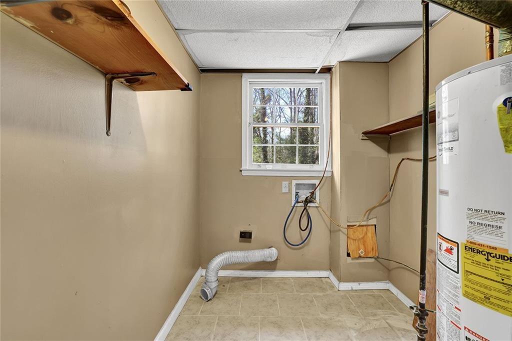 4341 Five Forks Trickum Road Southwest Lilburn, GA 30047 - Photo 26 of 35 a bathroom with a granite countertop sink a mirror and a window