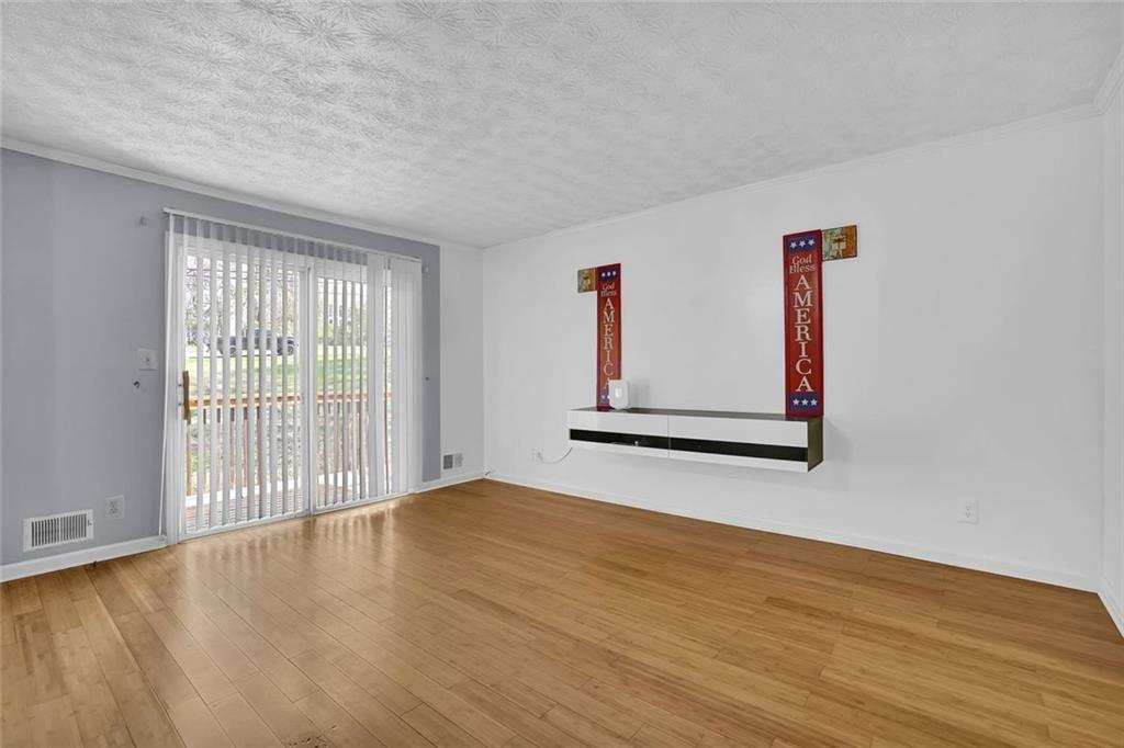 4341 Five Forks Trickum Road Southwest Lilburn, GA 30047 - Photo 3 of 35 a view of an empty room with wooden floor and a window