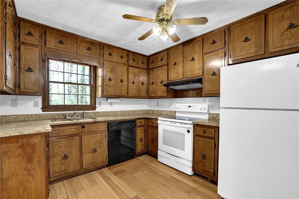 4341 Five Forks Trickum Road Southwest Lilburn, GA 30047 - Photo 7 of 35 a kitchen with stainless steel appliances granite countertop a stove a sink dishwasher and a refrigerator