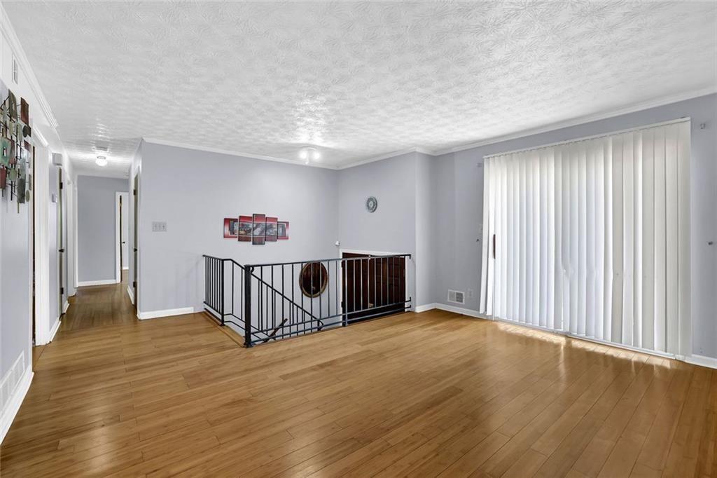 4341 Five Forks Trickum Road Southwest Lilburn, GA 30047 - Photo 8 of 35 a view of an empty room with wooden floor