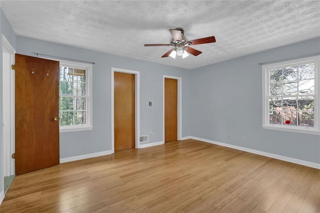 4341 Five Forks Trickum Road Southwest Lilburn, GA 30047 - Photo 9 of 35 a view of an empty room with window and wooden floor
