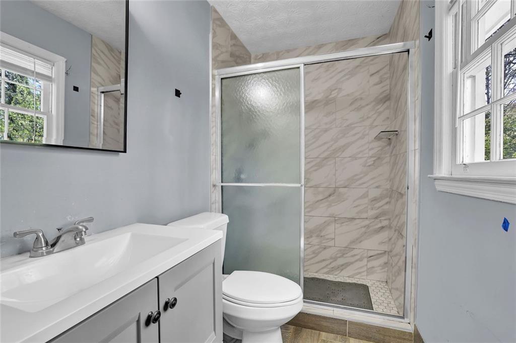 4341 Five Forks Trickum Road Southwest Lilburn, GA 30047 - Photo 10 of 35 a bathroom with a granite countertop sink toilet and shower