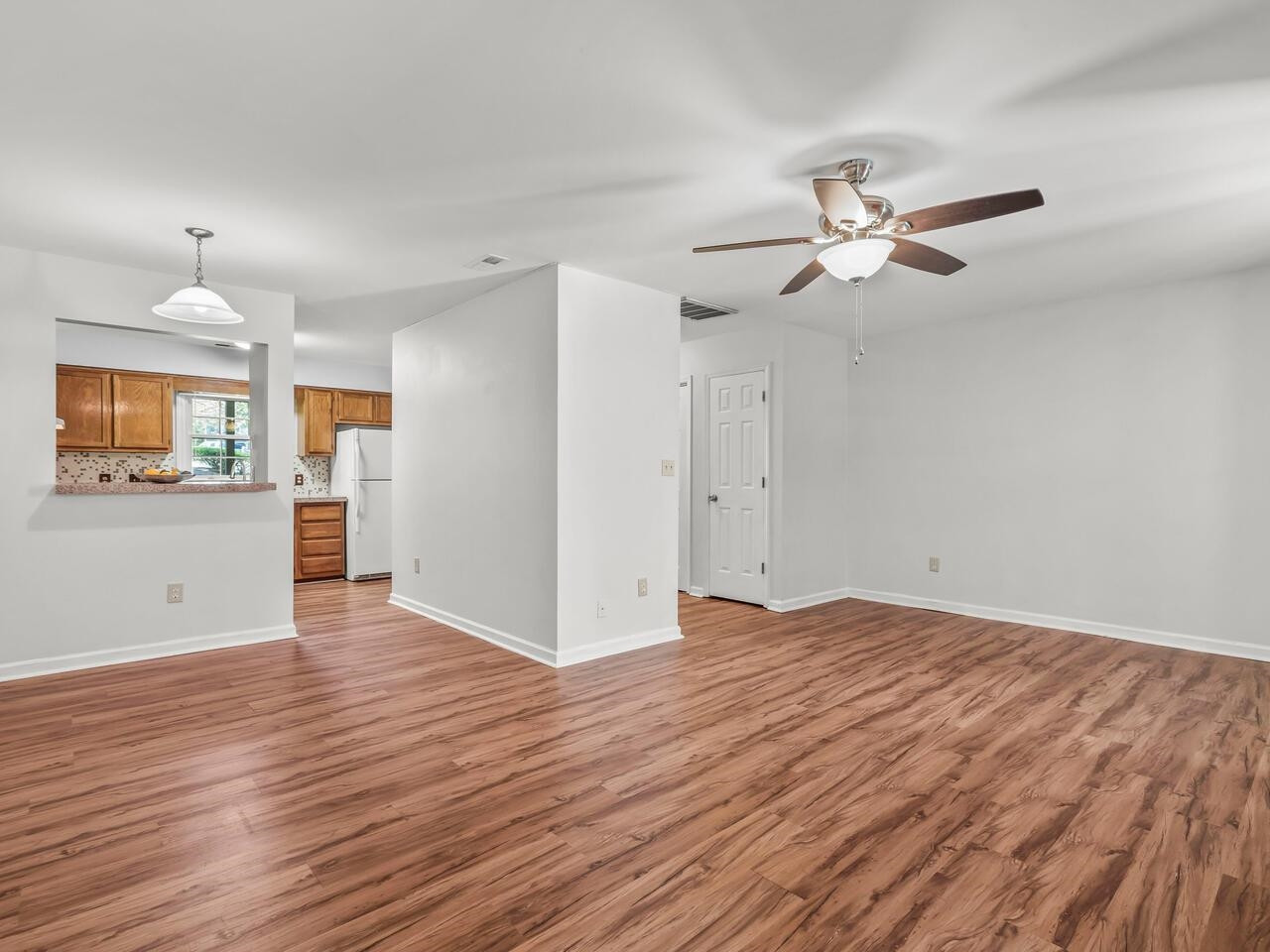 118 Shady Spring Place Durham, NC 27713 - Photo 11 of 33 a view of a kitchen with wooden floor and a ceiling fan