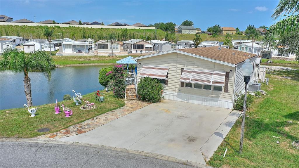 an aerial view of a house with a garden and lake view