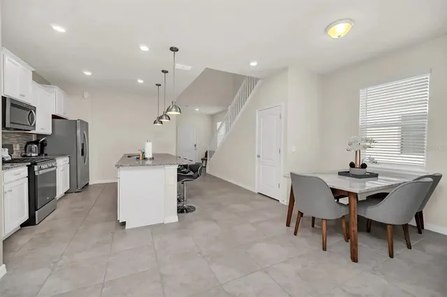 a living room with furniture a large window and white walls