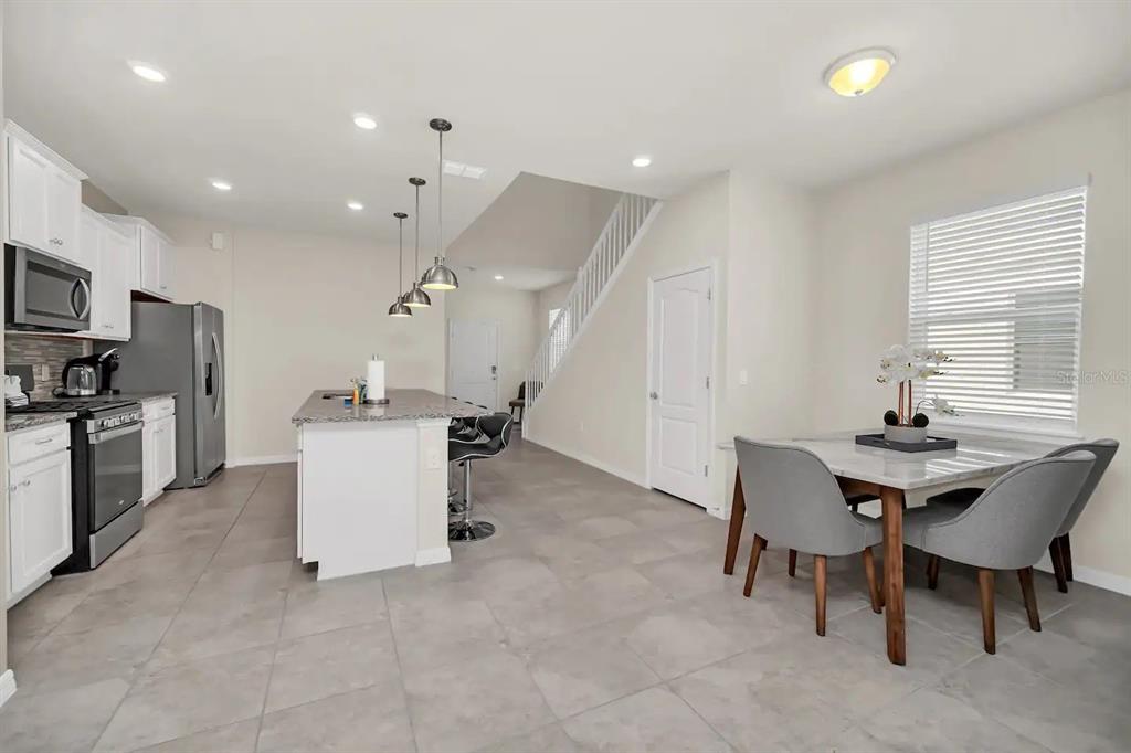 7263 Oakmoss Loop Davenport, FL 33837 - Photo 11 of 57 a living room with furniture a dining table and kitchen view