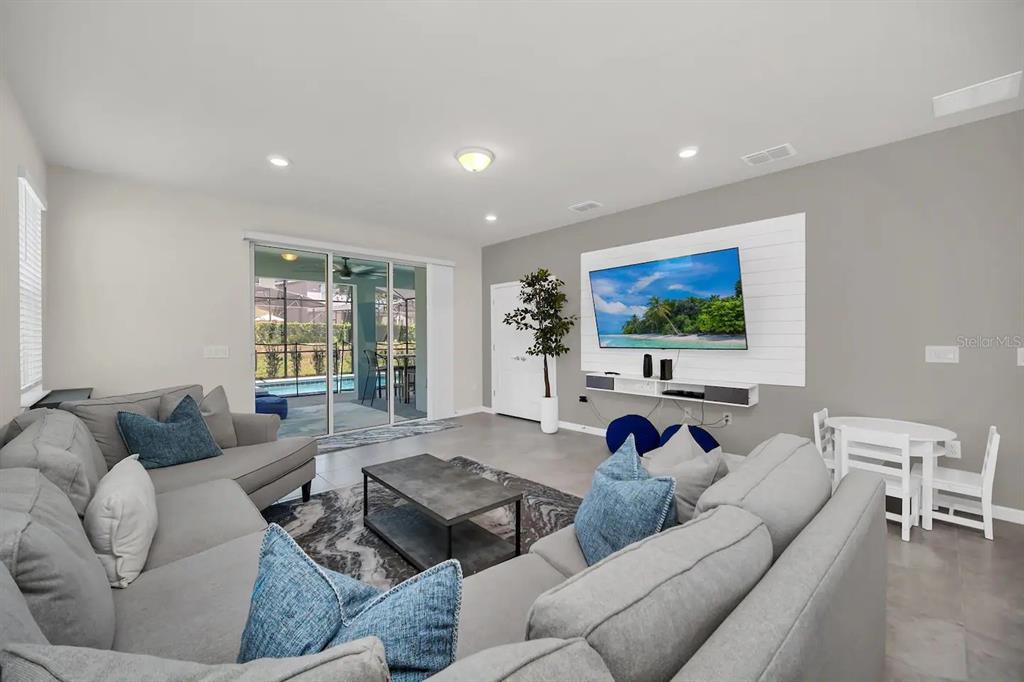 7263 Oakmoss Loop Davenport, FL 33837 - Photo 16 of 57 a living room with furniture and a flat screen tv