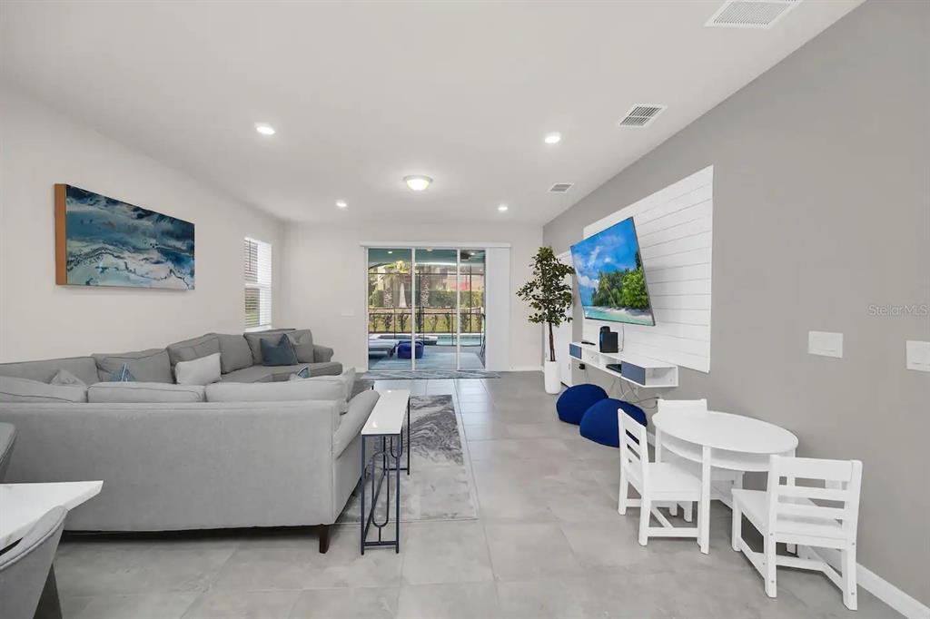 7263 Oakmoss Loop Davenport, FL 33837 - Photo 17 of 57 a living room with furniture a flat screen tv and a large window