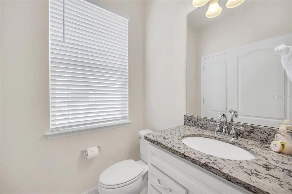 7263 Oakmoss Loop Davenport, FL 33837 - Photo 20 of 57 a bathroom with a granite countertop sink toilet and mirror