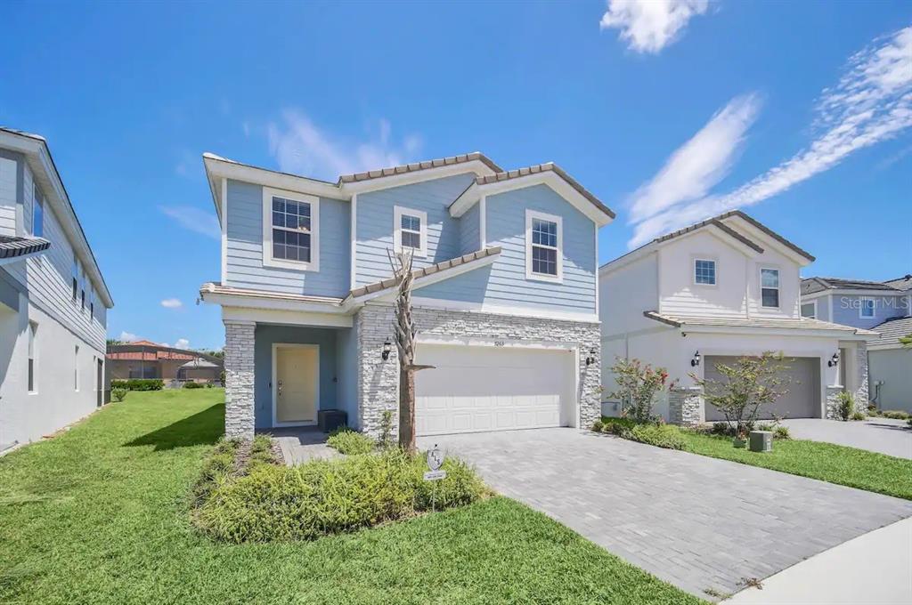 7263 Oakmoss Loop Davenport, FL 33837 - Photo 2 of 57 a front view of a house with a yard and garage