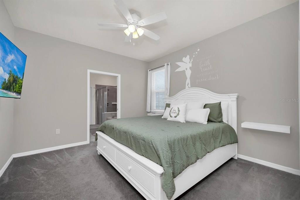 7263 Oakmoss Loop Davenport, FL 33837 - Photo 21 of 57 a bedroom with a bed and a chandelier