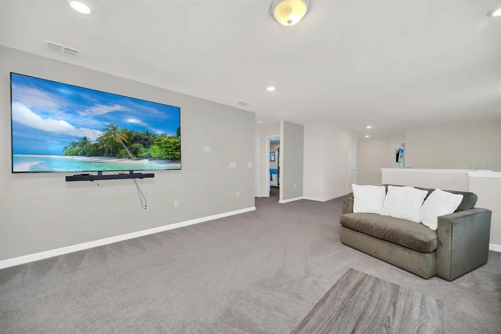 7263 Oakmoss Loop Davenport, FL 33837 - Photo 27 of 57 a living room with furniture and a painting on the wall