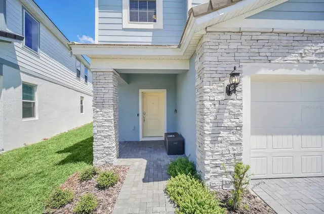 a kitchen with stainless steel appliances granite countertop a sink a stove a refrigerator and chairs