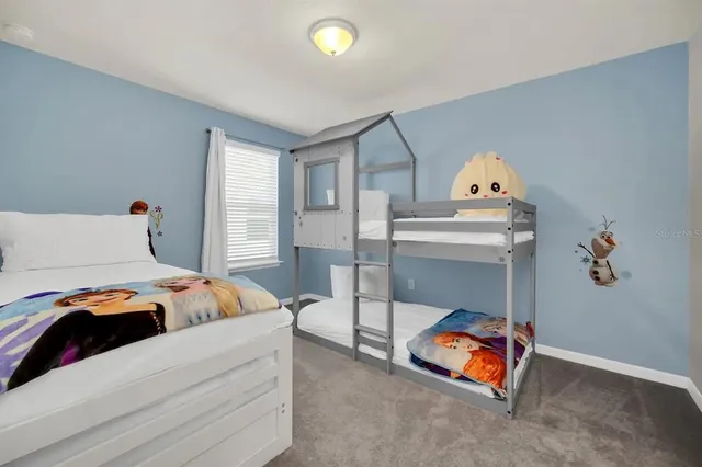 a bedroom with a large bed and a chandelier