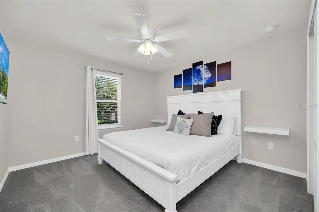 7263 Oakmoss Loop Davenport, FL 33837 - Photo 35 of 57 a bedroom with a large bed and a chandelier