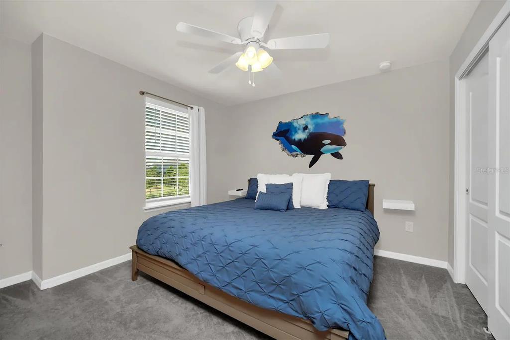 7263 Oakmoss Loop Davenport, FL 33837 - Photo 36 of 57 a bedroom with a bed and a chandelier