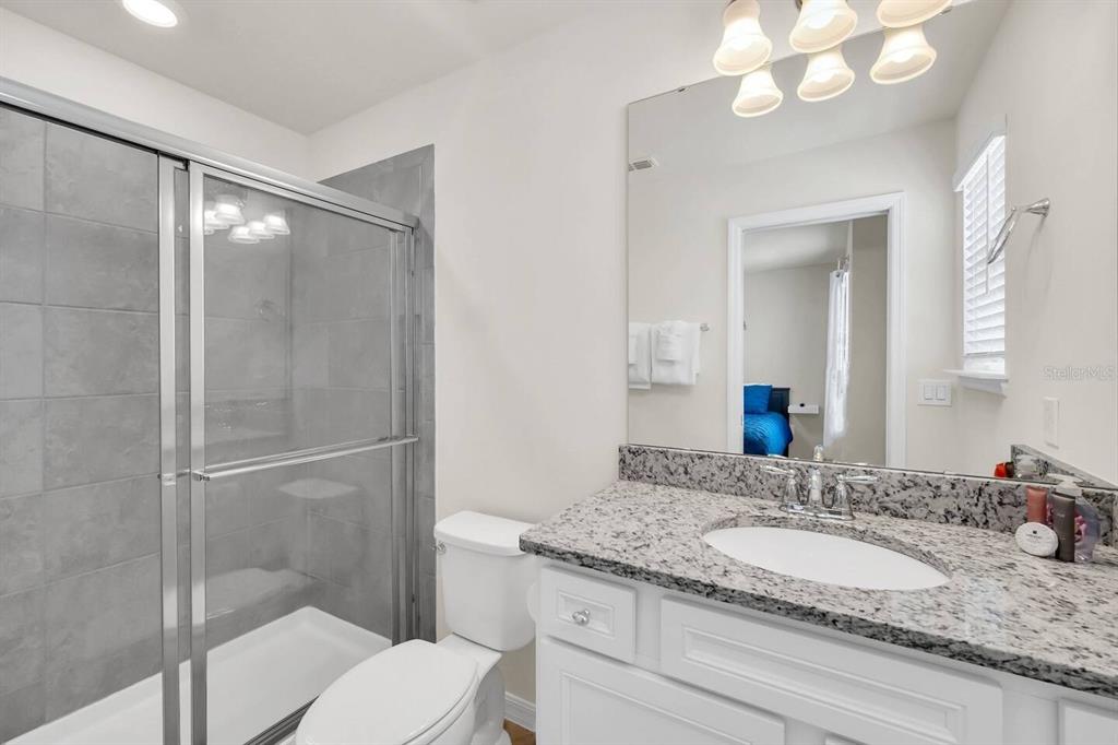 7263 Oakmoss Loop Davenport, FL 33837 - Photo 38 of 57 a bathroom with a granite countertop sink toilet and shower