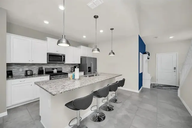 a large kitchen with kitchen island a sink table and chairs