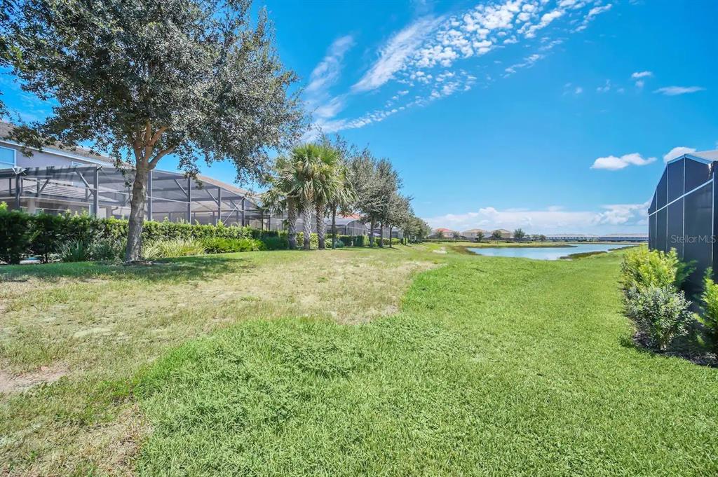 7263 Oakmoss Loop Davenport, FL 33837 - Photo 57 of 57 a backyard of a house with lots of green space and lake view