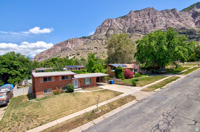 1272 Cook Street Ogden, UT 84404 - Photo 46 of 46 Brick exterior residence featuring a carport, front yard, and prominent mountain backdrop