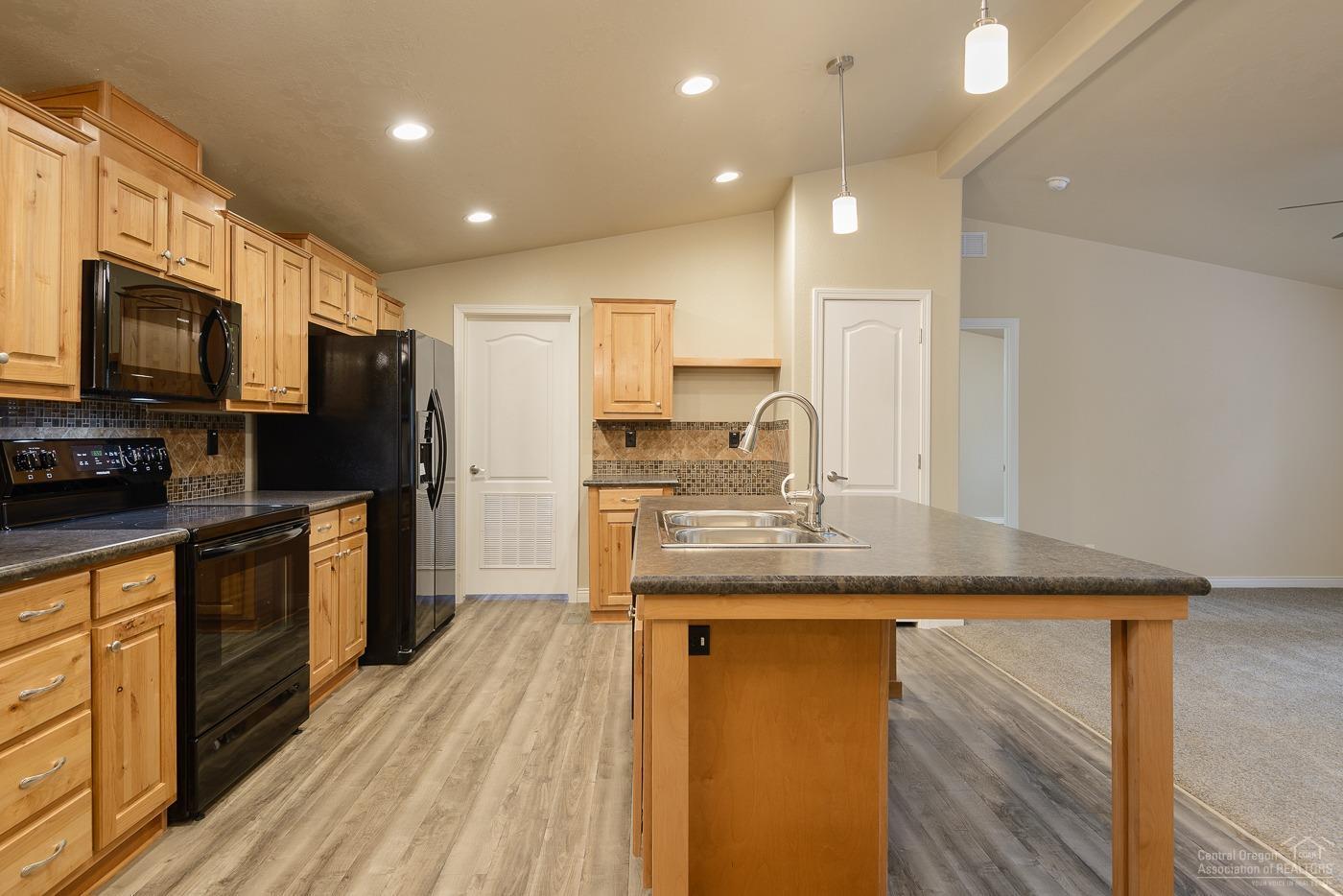 17237 Jacinto Road Bend, OR 97707 - Photo 2 of 20 a kitchen with stainless steel appliances granite countertop a sink refrigerator and microwave