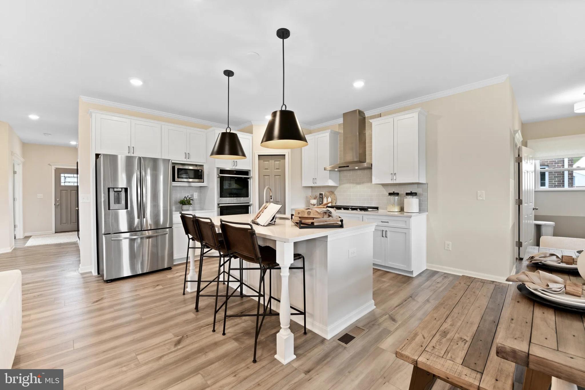 3 Bowens Run Road Bealeton, VA 22712 - Photo 1 of 14 a kitchen with stainless steel appliances kitchen island granite countertop a stove a refrigerator a dining table and chairs with wooden floor