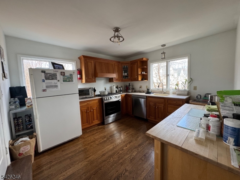 630 Valley Road Gillette, NJ 07933 - Photo 20 of 30 a kitchen with a refrigerator a sink dishwasher and a stove with wooden floor