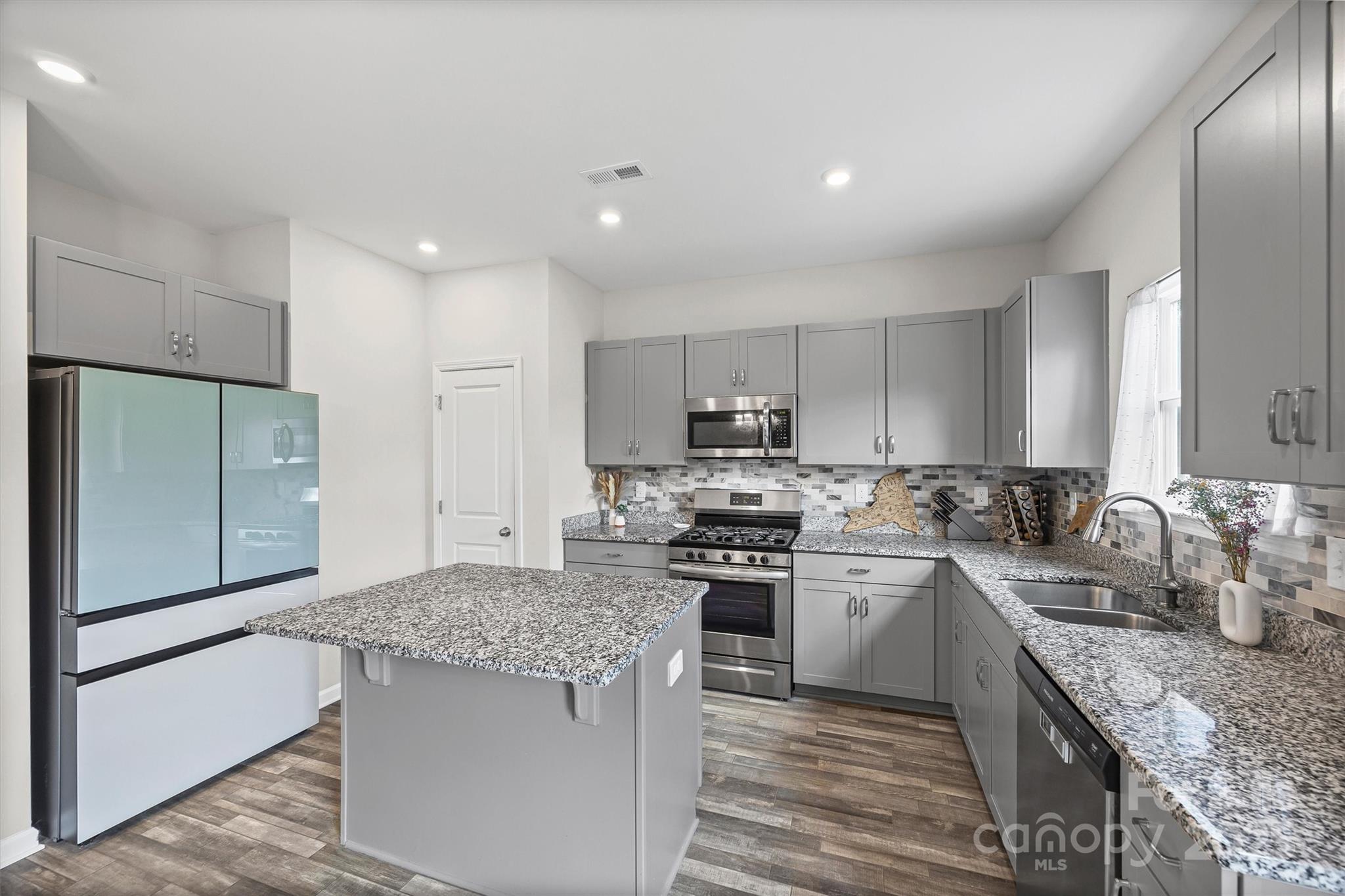328 Cold Crk Way Mount Holly, NC 28120 - Photo 3 of 24 a kitchen with stainless steel appliances granite countertop a stove refrigerator sink and dishwasher