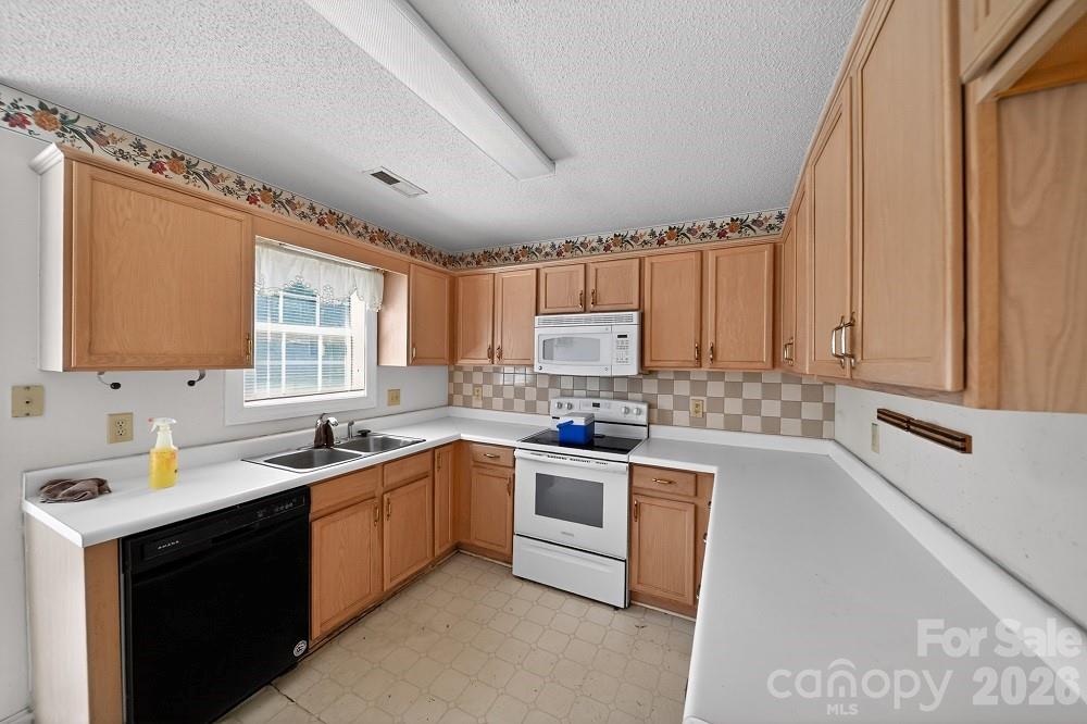 2205 Old Sparta Road Rocky Mount, NC 27804 - Photo 6 of 25 a kitchen with a sink stove and cabinets
