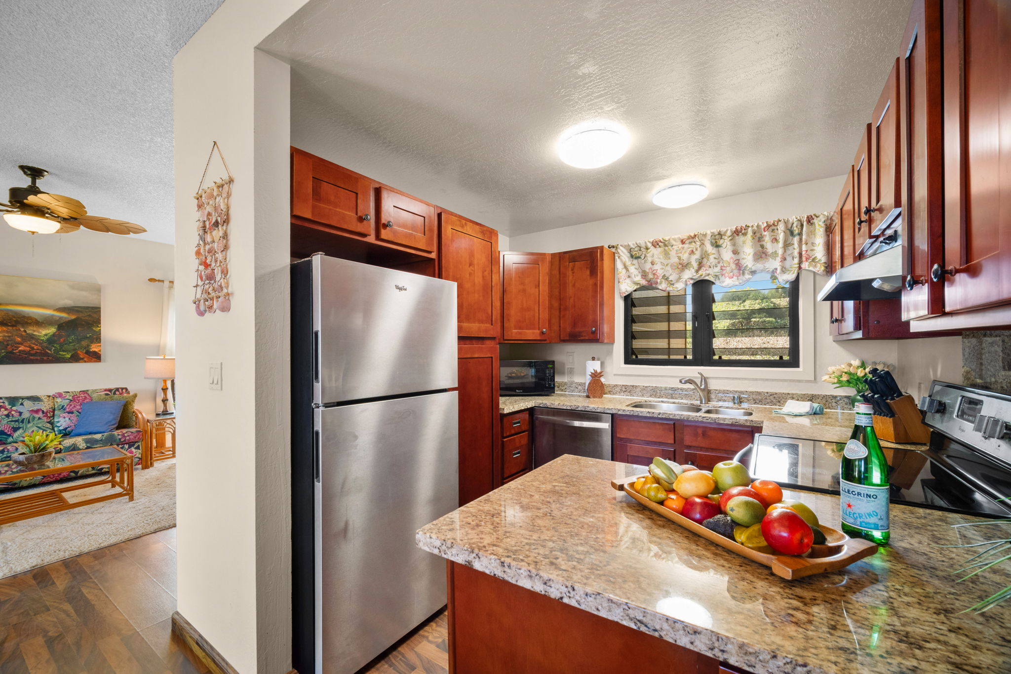 4460 Nehe Road, Unit 203 Lihue, HI 96766 - Photo 7 of 26 a kitchen with granite countertop stainless steel appliances a refrigerator stove and sink