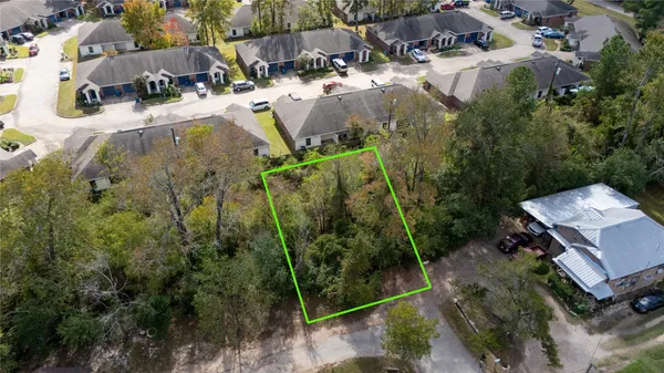 an aerial view of residential house with outdoor space and trees all around