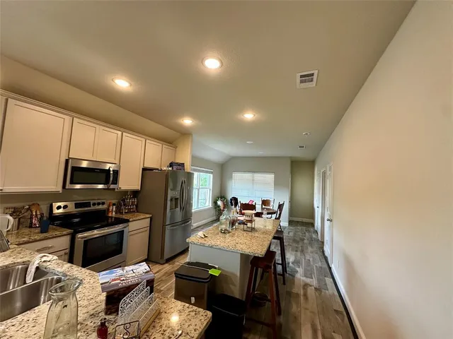 a kitchen with sink refrigerator and microwave