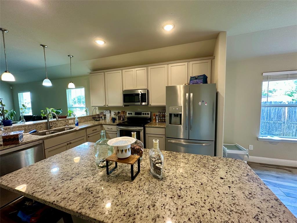 2801 Stuart Drive Fort Worth, TX 76104 - Photo 13 of 39 a kitchen with stainless steel appliances kitchen island granite countertop a refrigerator stove top oven dining table and chairs