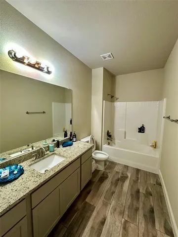 a bathroom with a granite countertop sink a large mirror and a bathtub