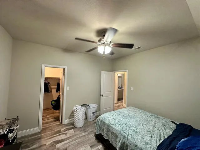a bedroom with bed and wooden floor
