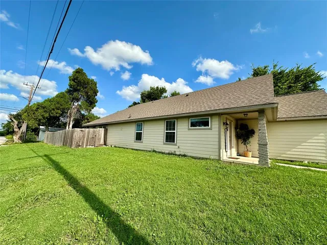 a view of a house with a big yard and potted plants