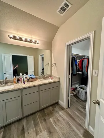 a en suite bathroom with a double vanity sink and a mirror
