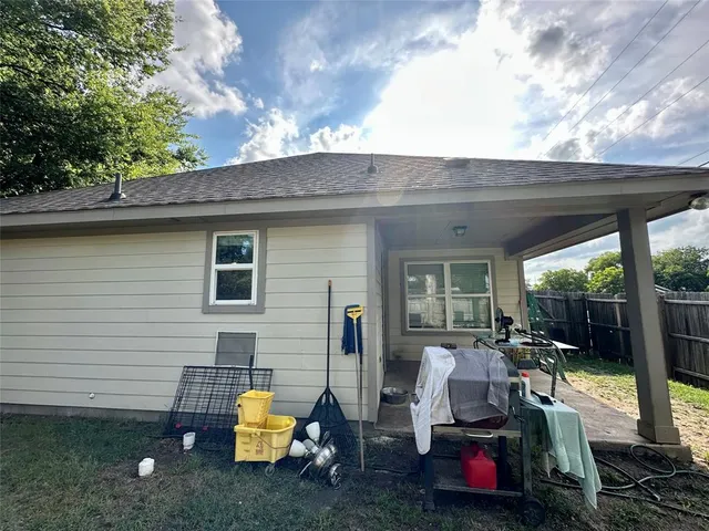 a backyard of a house with barbeque oven table and chairs