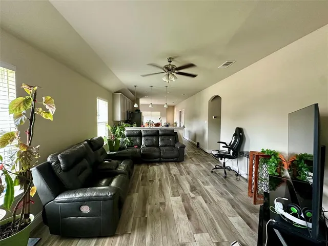 a living room with furniture and a wooden floor