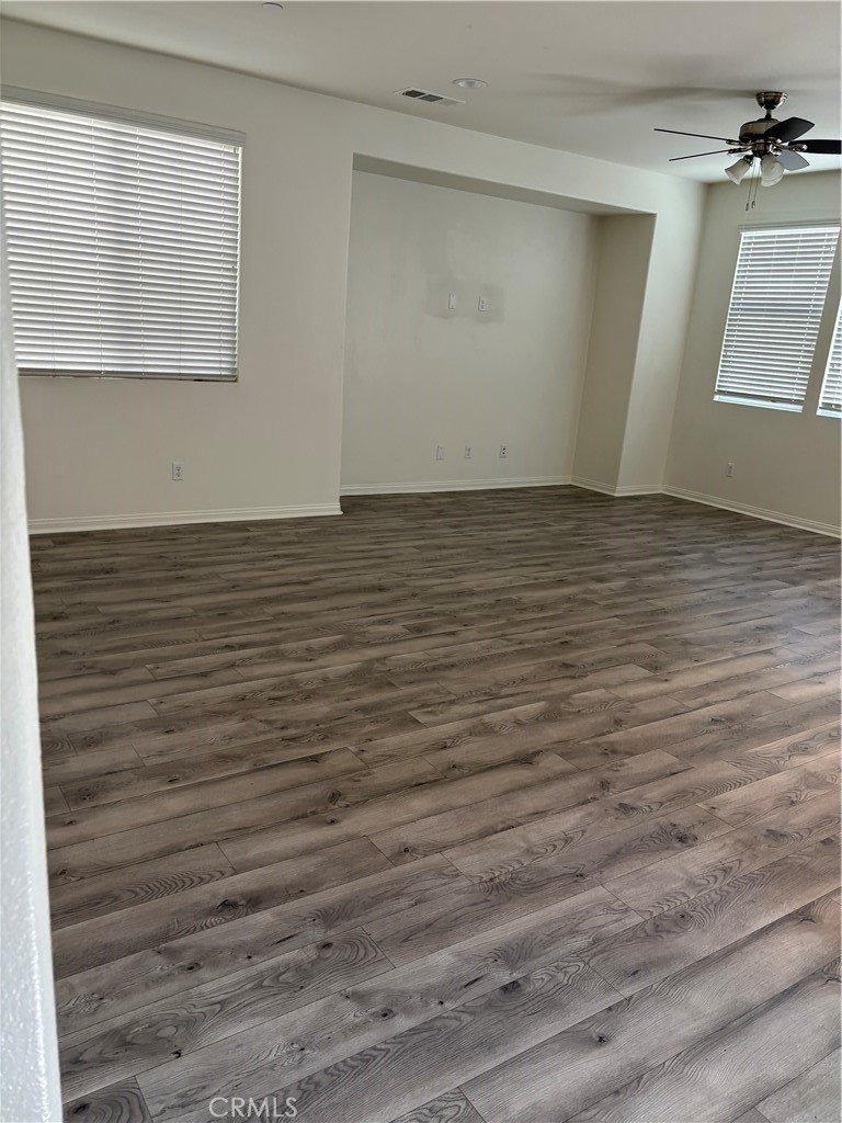 28434 Sunflower Street Highland, CA 92346 - Photo 4 of 22 an empty room with wooden floor and windows
