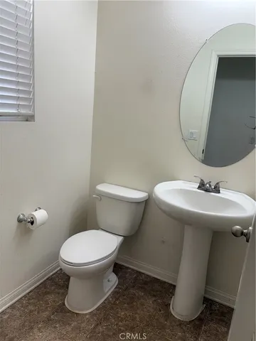 a white toilet sitting next to a bathroom sink