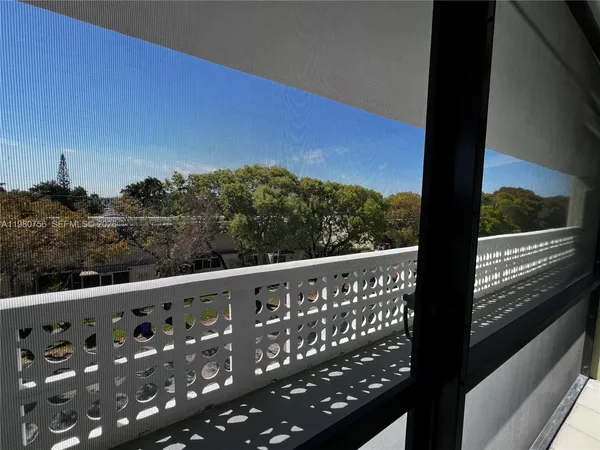 a view of a refrigerator in kitchen and an empty room