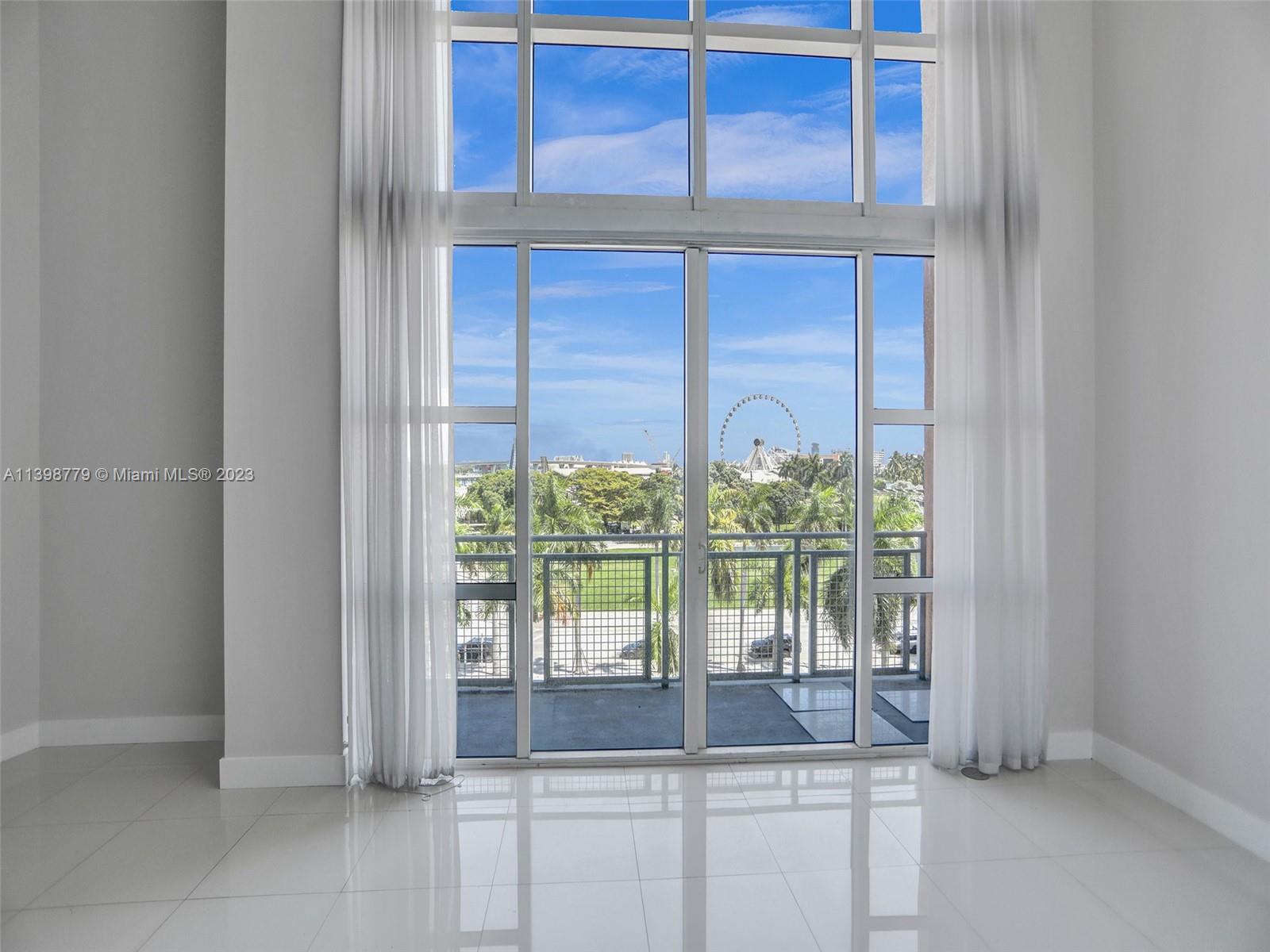 244 Biscayne Boulevard, Unit 439 Miami, FL 33132 - Photo 11 of 49 a view of a room with a floor to ceiling window and wooden floor