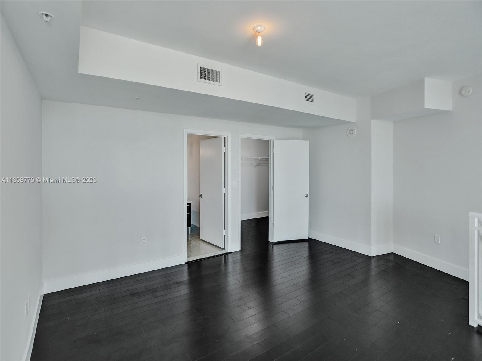244 Biscayne Boulevard, Unit 439 Miami, FL 33132 - Photo 15 of 49 a view of an empty room with wooden floor