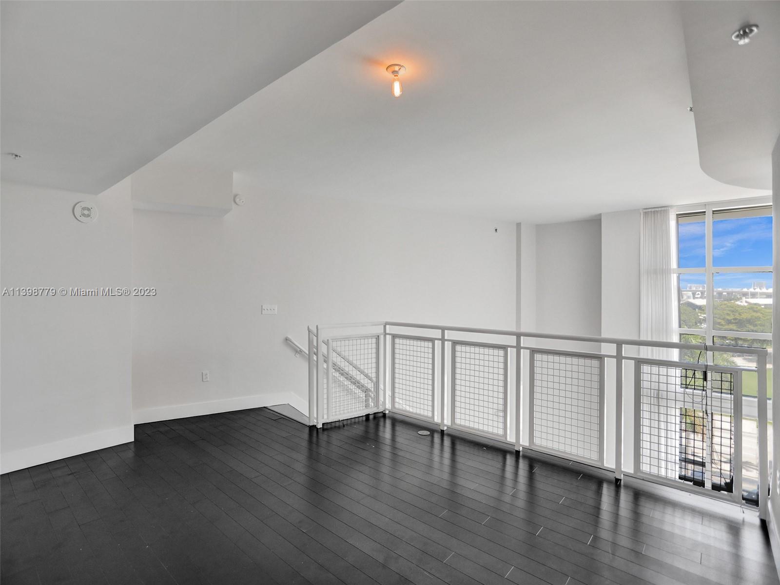 244 Biscayne Boulevard, Unit 439 Miami, FL 33132 - Photo 16 of 49 a view of an empty room with wooden floor