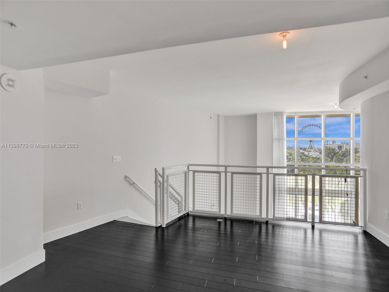244 Biscayne Boulevard, Unit 439 Miami, FL 33132 - Photo 20 of 49 a view of an empty room with wooden floor and a window