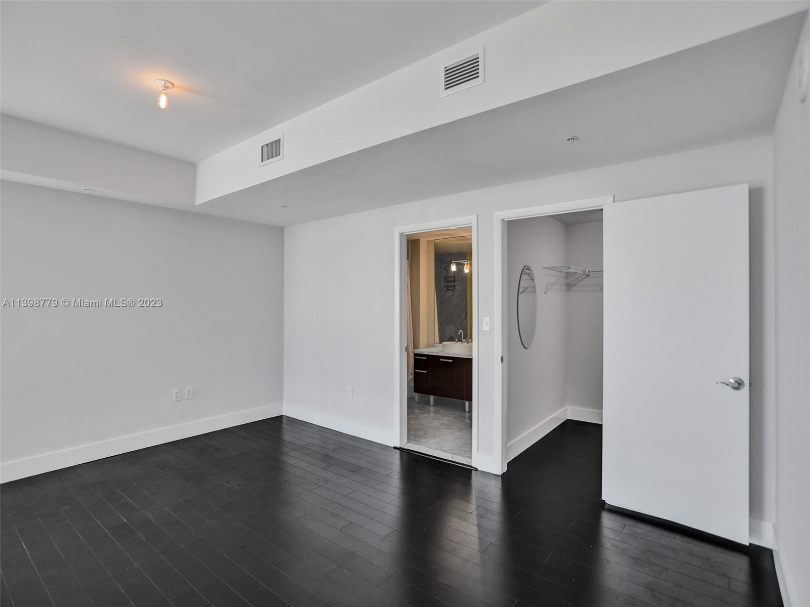 244 Biscayne Boulevard, Unit 439 Miami, FL 33132 - Photo 26 of 49 a view of an empty room with wooden floor and closet