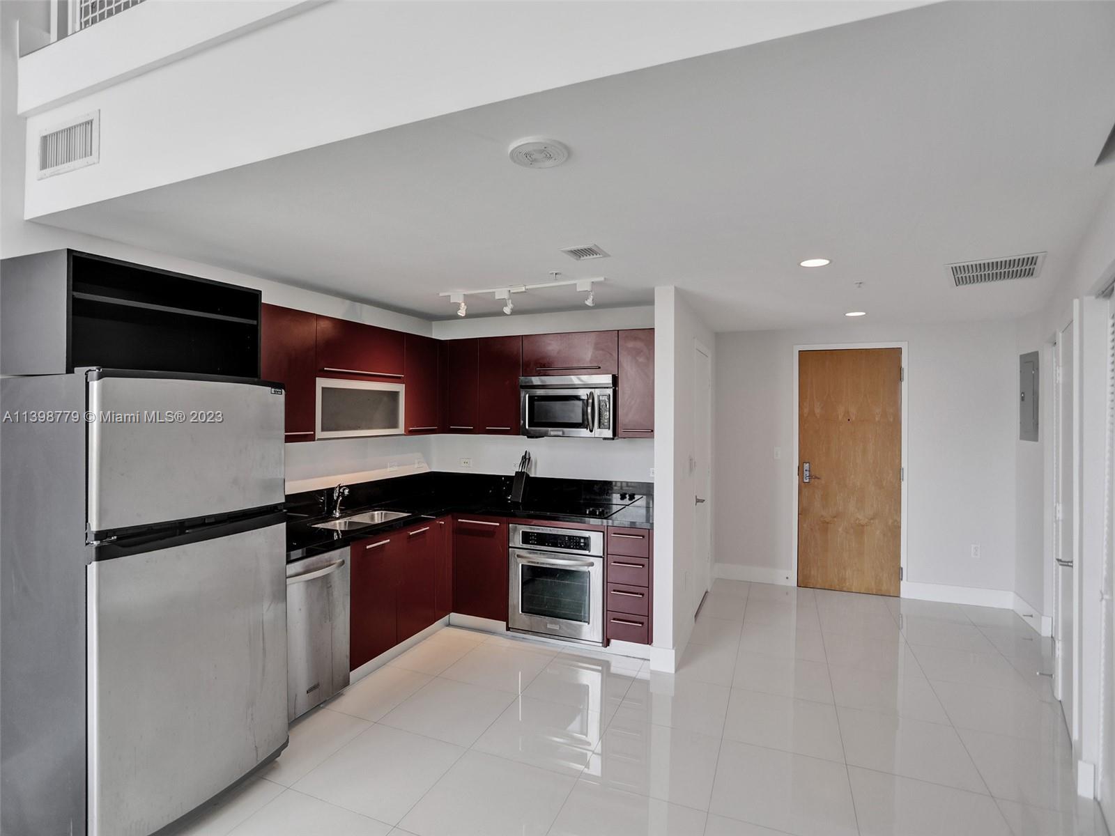 244 Biscayne Boulevard, Unit 439 Miami, FL 33132 - Photo 4 of 49 a kitchen with stainless steel appliances granite countertop a refrigerator and a sink